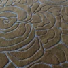 Close-up of Bloom Wool 15897 luxury designer rug in brown, handmade with blue-outlined abstract floral pattern.