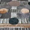 Atlas Hide 30060 luxury designer rug features gray-brown patchwork and bold, multicolored circles.