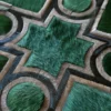 Close-up of a luxury custom designer rug, handmade from green and brown hide, with circles and crosses in high-end geometric pattern.
