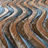 Close-up of luxury designer hide rug with wavy brown and gray fur in a zigzag pattern.