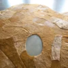 Close-up of Portal Hide 25165, a luxury designer rug with brown and tan abstract patterns and a smooth oval cutout.