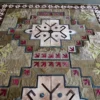 Winterlude Hide 26020 is a high-end designer rug featuring geometric motifs in beige, brown, red, and blue.