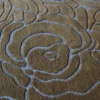 Close-up of luxury designer Bloom Wool 15897 rug with a textured, abstract floral pattern in high-end brown and bluish-gray wool.