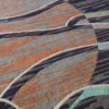 Close-up of luxury custom wool designer rug with abstract textured pattern in gray, brown, orange, and teal.