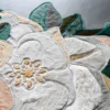 A close-up of the Sweet Hide 26095 luxury designer rug with textured floral patterns in premium faux fur on a smooth gray base.