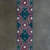 High-end designer Kasbah Hide 15910 runner rug in teal with pink, gold, and white geometric patterns on a gray concrete floor.