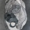 Luxury designer rug with irregular gray and white shapes, handmade hide, on dark floor.