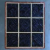 A grid of nine dark blue textured tiles with beige lines, luxury designer hide rug.