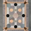 Luxury designer rug Atlas Hide 30060 with geometric patterns in gray, beige, and brown on concrete floor.