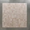 A large square panel of luxury designer rug tiles in beige and light brown hues on a gray wall.