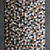 Luxury designer rug with blue, copper, gray, and white hexagons on gray background.