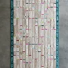 Luxury designer rug with vertical translucent strips, turquoise border, and colorful tabs.