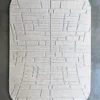 A luxury designer rug, the Tower Silk Wool 26836, features hand-tufted silk and wool in light gray with a geometric raised pattern on a dark floor.