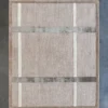 Luxury designer rectangular beige rug with grid pattern, handmade silk and wool, on dark floor.