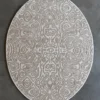The Urushi Silk, Wool 15647 is a luxury designer round beige rug with an intricate pattern on a solid gray floor.