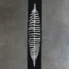 Luxury custom wool runner rug with white abstract leaf, high-end designer style on concrete.
