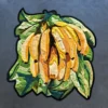 Luxury designer rug featuring layered textile bananas and green leaves on gray background.