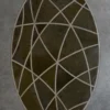 Luxury designer oval rug Silhouette Hide 27680 with abstract curves in brown on gray floor.