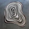 Luxury designer rug featuring handmade irregular ovals in brown, gray, and beige on a chic gray backdrop.