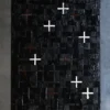 A luxury designer rug with black texture, intersecting grids, and white-brown plus signs.