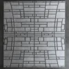 Rectangular metallic panel inspired by luxury designer rug patterns, set on a textured dark gray wall.