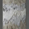 Luxury designer rug with geometric metallic and matte shapes in silver, gray, and beige.