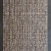Luxury designer rug with a geometric brown and white pattern on a dark gray floor.