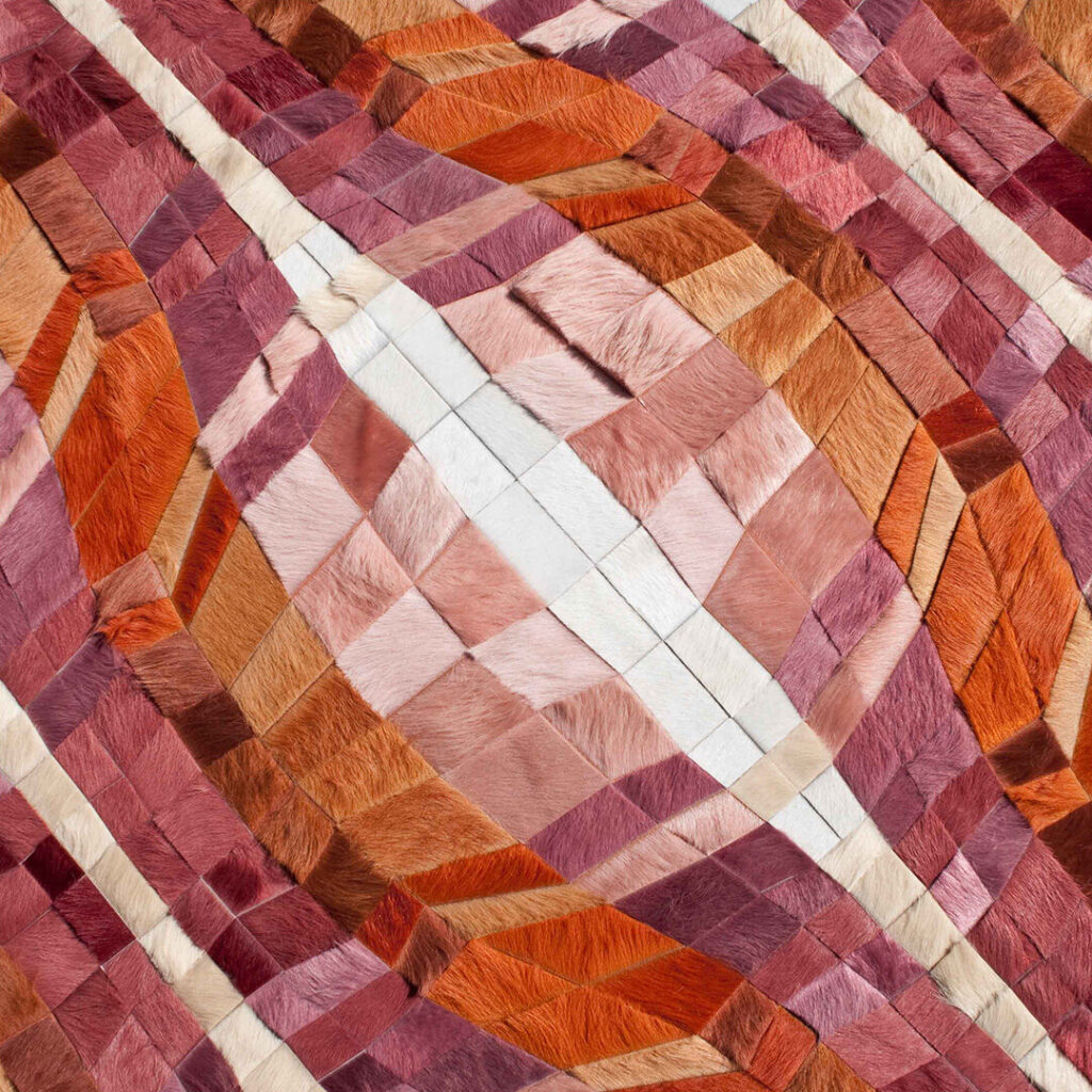 Luxury designer rug featuring a geometric patchwork of handmade hide in rich tones.