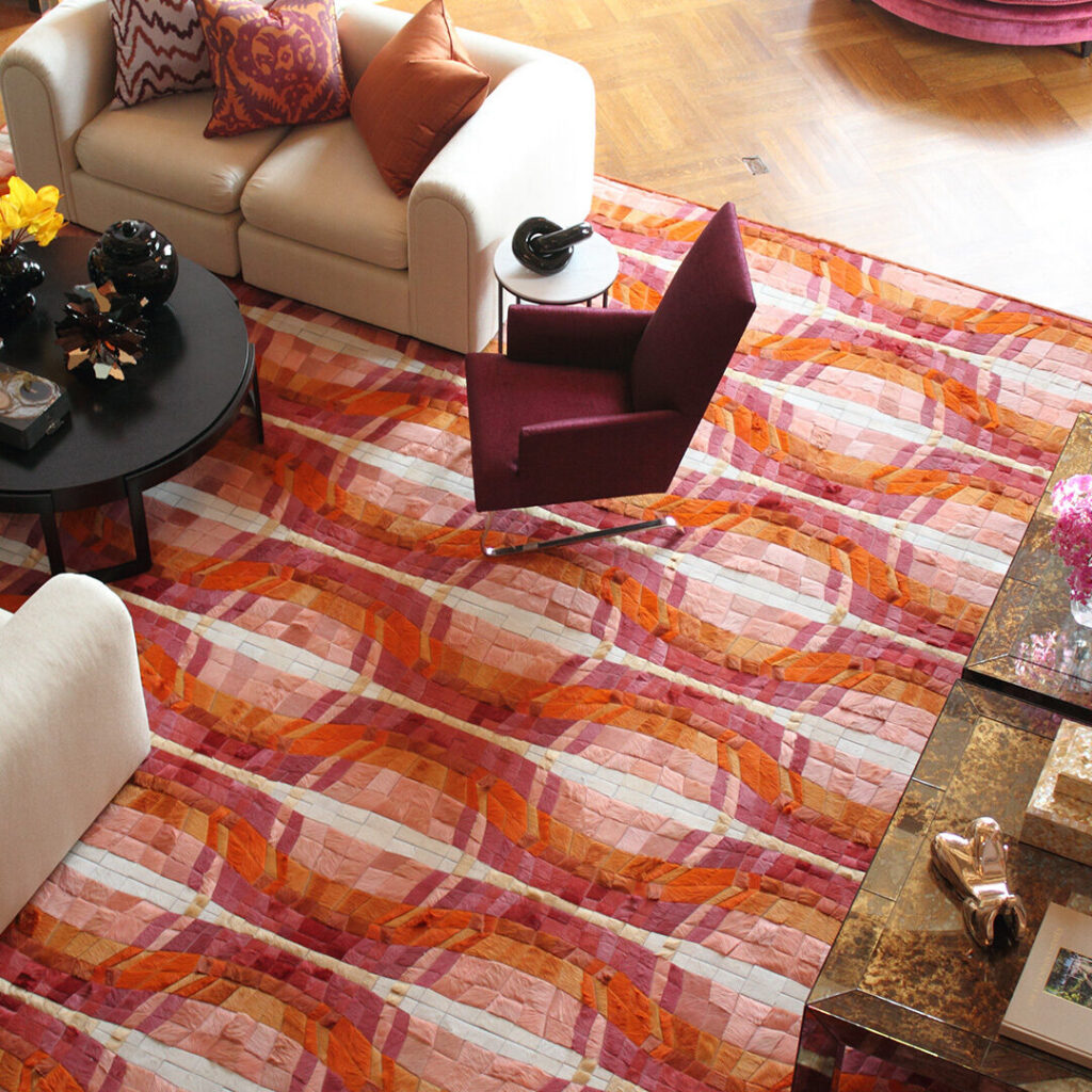 Living room featuring a luxury designer rug in red and pink, with cream sofas and upscale decor.