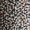 Luxury designer rug with interlocking hexagonal patches in brown, black, and gray.